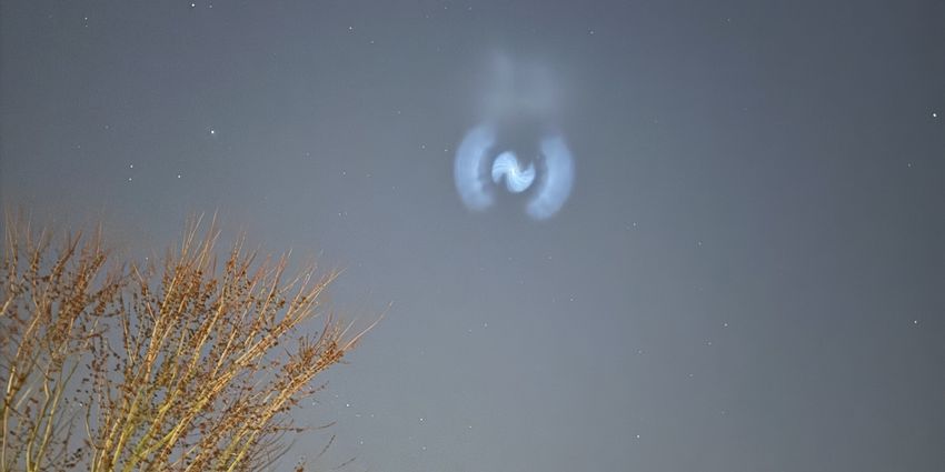 Hamburg 2025 - Treibstoffausstoß von Rakete Lichterscheinung am Himmel, die außen aus zwei halbkreisförmigen Wolken und mittig aus einer spiralförmigen Wolke besteht.